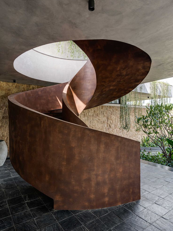 Escalier sur mesure Maroc hélicoïdal sculptural en métal finition effet Corten dans un espace architectural contemporain